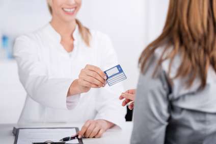 Foto: Patientin und Arzthelferin mit Versicherungskarte 